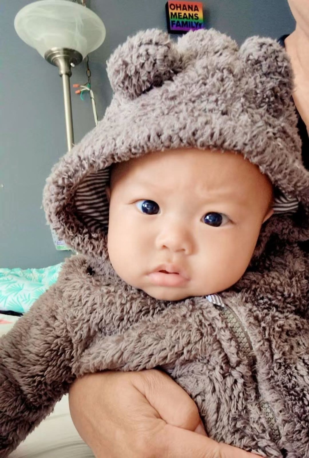 Baby Koa in a soft bear outfit during his early months