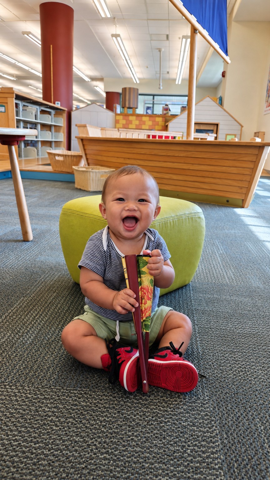 Koa laughing with a book during a library visit