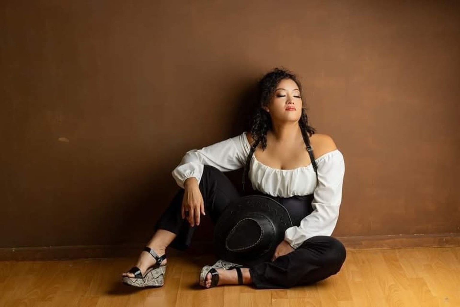 Leimomi seated in a grounded studio portrait